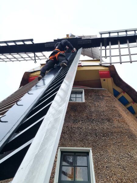 De mannen van Jan Vet Monumenten beklimmen ook zonder aarzeling de wieken